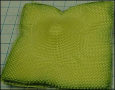 Kevlar fabric with shear thickening fluid, after impact by a fragment simulating projectile.