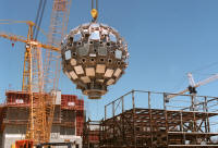 The 10-meter-diameter target chamber is lifted into place in June 1999. The spherical vacuum vessel was installed at Lawrence Livermore National Laboratory with one of the largest cranes in the world.