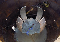 The single largest piece of equipment at the National Ignition Facility is its 130-ton target chamber. The design features 6 symmetric middle plates and 12 asymmetric outer plates, which were poured at the Ravenswood Aluminum Mill in Ravenswood, West Virginia. The plates were shipped to Creusot-Loire Industries in France, where they were heated and shaped in a giant press. The formed plates were then shipped to Precision Components Corp. in York, Pennsylvania, where they were trimmed and weld joints prepared. Assembly of the target chamber at Lawrence Livermore National Laboratory (seen here) was then performed in a temporary cylindrical steel enclosure. 