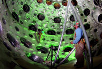 Construction workers install equipment inside the target chamber at the National Ignition Facility