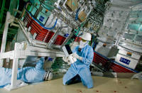 Lawrence Livermore National Laboratory technicians John Hollis (right) and Jim McElroy install a SIDE camera in the target bay of the NIF in January of 2009. The camera was the last of NIF's 6,206 various opto-mechanical and controls system modules called "line replaceable units" or LRUs to be installed. The first LRU, a flashlamp, was installed on Sept. 26, 2001