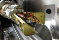 On October 6th, 2010, the target assembly holding the hohlraum with its tiny capsule inside is mounted in the cryogenic target positioning device at the NIF. The two copper-colored arms form a shroud around the cold target to protect it until they open five seconds before a shot.